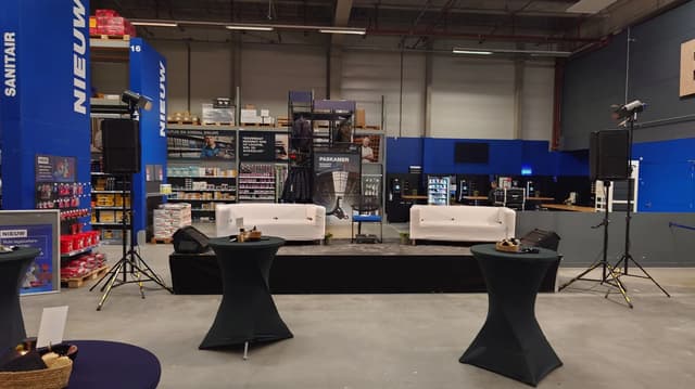 Evenementopstelling met twee duidelijk zichtbare luidsprekers naast het podium