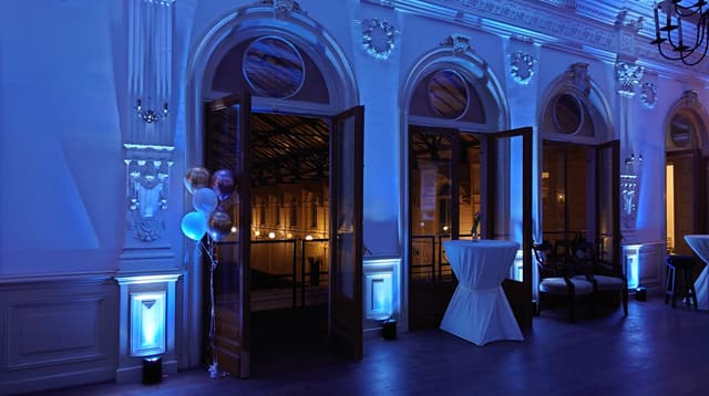Eventruimte met blauwe uplighting langs de monumentale wanden